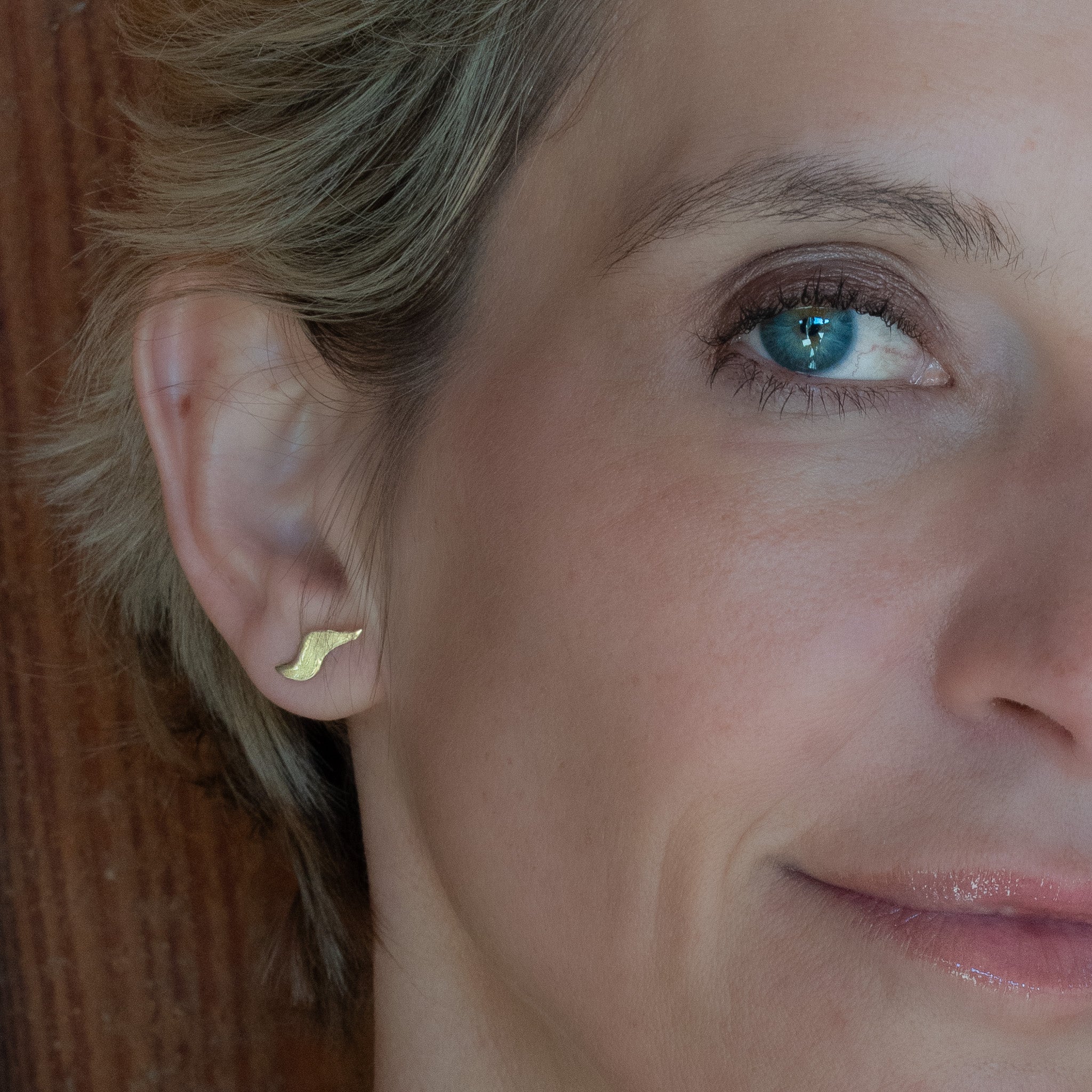 Flame Earrings in bronze, close-up side view on ear — Zefiro Jewels
